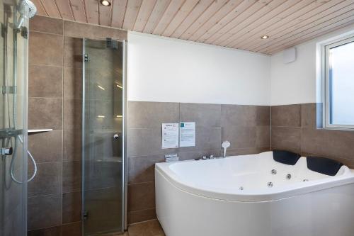 a bathroom with a bath tub and a shower at Charming Cottage In Fjellerup With Indoor Spa in Glesborg