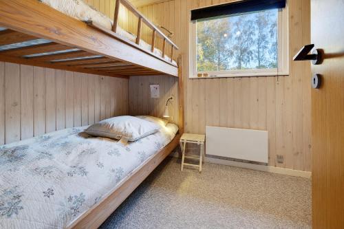 a bedroom with two bunk beds and a window at Scenic Summer House On Langeland in Humble
