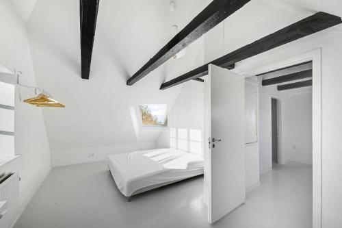 a bedroom with a bed in a white room at Lovely Spacious Holiday Home On Bornholm in Hasle