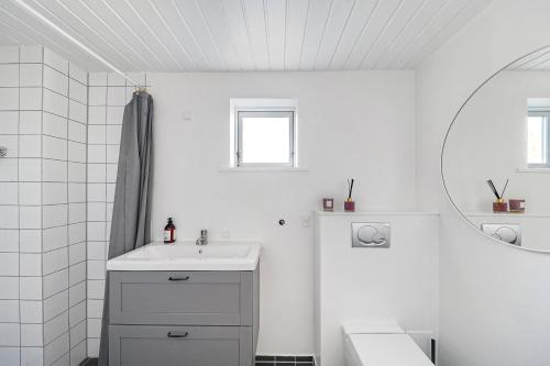 a white bathroom with a sink and a mirror at Lovely Spacious Holiday Home On Bornholm in Hasle
