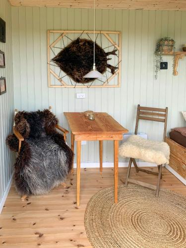 a room with a wooden table and a chair at Shepherd's Hut With Lake View In Ollerup in Vester-Skerninge