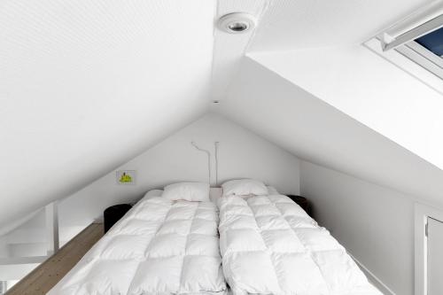a white bed in a white room with a window at Bornholm Holiday Apartment With Sea View in Allinge