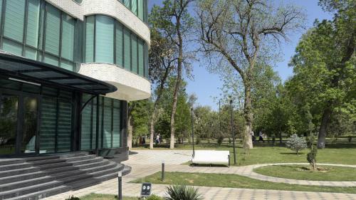 a building with a bench next to a park at Horev Medical Center in Tashkent