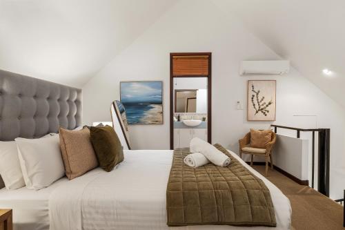 a bedroom with a large bed and a chair at Sidney Laine - Family Friendly - Private in Margaret River Town