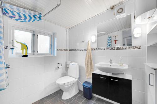 une salle de bains blanche avec toilettes et lavabo dans l'établissement Cottage On Fur Island With Exceptional Sea View, à Fur