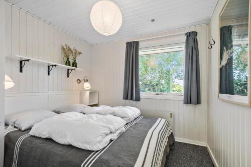 a bedroom with a large bed with white pillows at Bright And Cozy Summer House With Sea View in Hasle