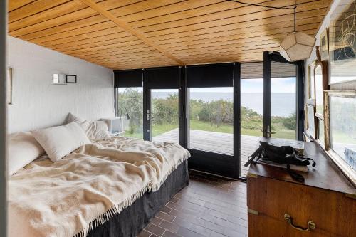 a bedroom with a large bed and a large window at Architect Designed Holiday Home With Sea View in Gudhjem