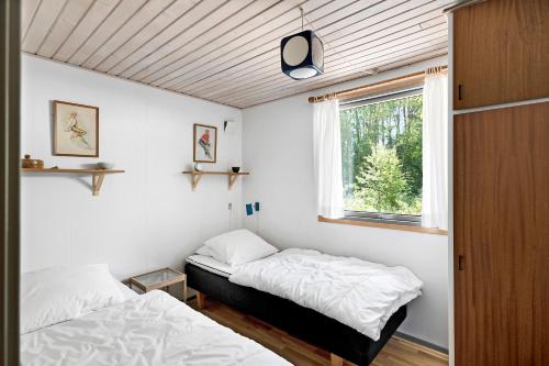 two beds in a room with a window at Cottage In Peaceful Surroundings In Vester Sømark in Vester Sømarken
