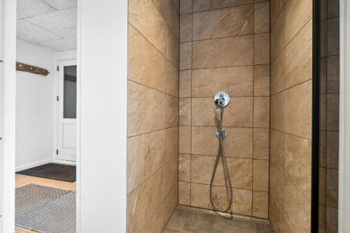 a shower in a bathroom with a phone on the wall at Modern House With Space For Relaxation in Åkirkeby