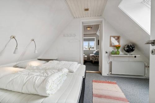 a white bedroom with a large bed in a attic at Modern House With Space For Relaxation in Åkirkeby