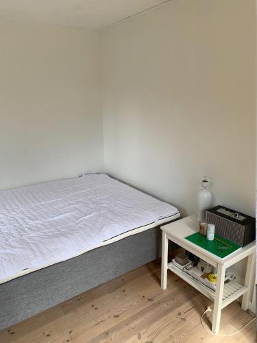 a bedroom with a bed and a small table at Cozy And Modernized Fishing Cabin in Hornslet