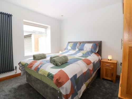 a bedroom with a bed with two pillows on it at Dalar Deg in Rhiw