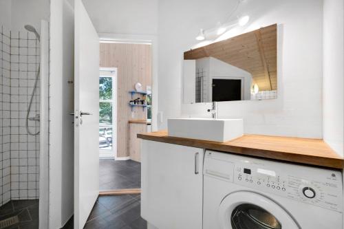 a white bathroom with a sink and a washing machine at Summer House In Beautiful Nature In Brunshuse in Hårby