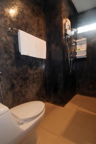 a bathroom with a toilet and a phone on the wall at BaanPhong Lanta in Ko Lanta