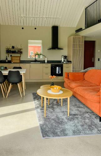 a living room with an orange couch and a table at Rural Cottage With Views Over Herrljunga in Ljung