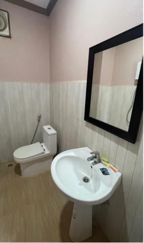 a bathroom with a sink and a toilet and a mirror at khounxub view hotel in Ban Pho Touane