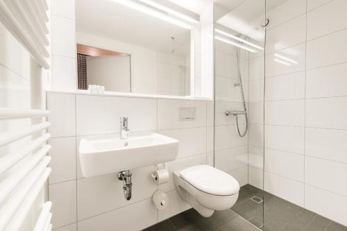 uma casa de banho branca com um WC e um lavatório em moveINN em Nordhorn