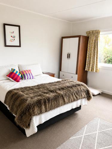 a bedroom with a large bed and a window at Farm Stay | Near Airport & Mystery Creek in Tamahere