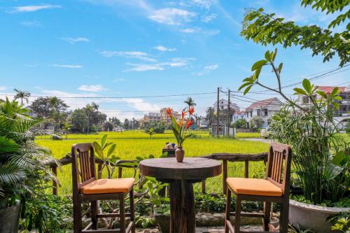 a table and two chairs and a table with a table at Hoi An Chic - Green Retreat in Hoi An