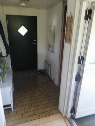 a hallway with a black door and a window at Holiday Home On A Huge Nature Plot in Skagen
