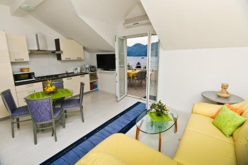 a living room with a yellow couch and a table at Apartments Villa Ana 1 in Cavtat