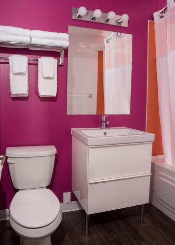 a bathroom with a white toilet and a sink at Hotel Zed Kelowna in Kelowna