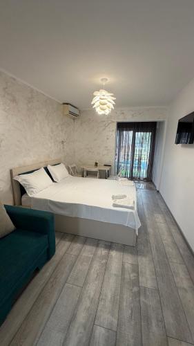 a bedroom with a large bed and a green couch at SAB Luxury Apartaments 2 Saturn in Saturn