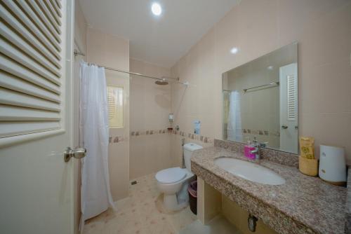 a bathroom with a sink and a toilet and a mirror at Nan's Aonang in Ao Nang 