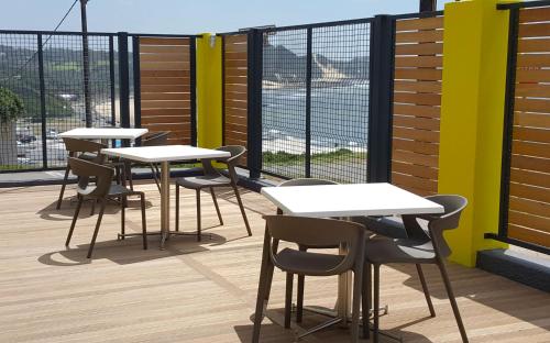 a row of tables and chairs on a balcony at The Paralian Exclusive Guest House in East London