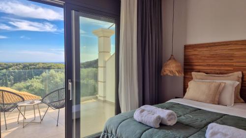a bedroom with a bed and a balcony with a view at Milion Living Residences in Parga