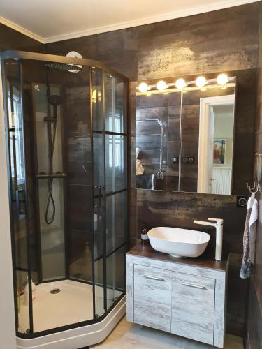 a bathroom with a glass shower and a sink at Kulla Gard in Ingarö