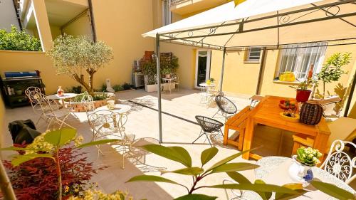 a patio with chairs and tables and a glassconservatory at R&B Dimora Teodorico in Ravenna