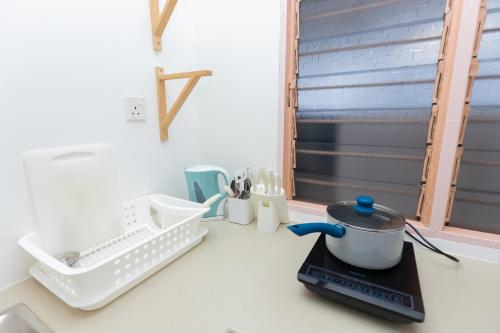 a kitchen counter with dishes and a tea kettle on it at Eastern Apartment in Jelutong