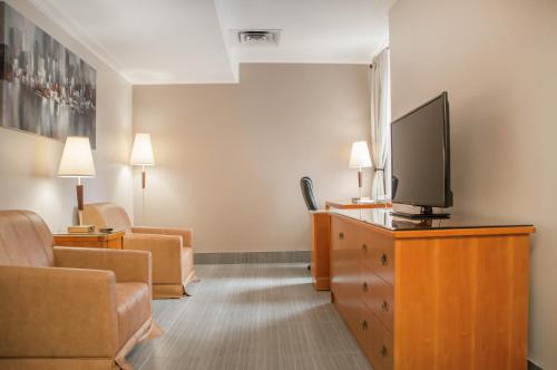 a living room with a tv on a dresser at Empire Suites in Montréal
