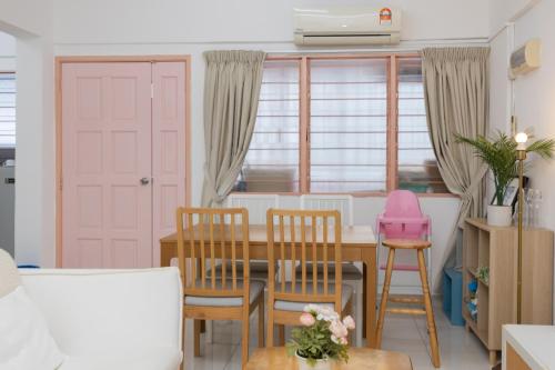 a kitchen with a dining room table and chairs at Eastern Apartment in Jelutong