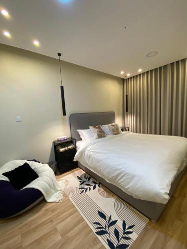 a bedroom with a large bed and a rug at شقة هادئة مودرن in Al Khobar