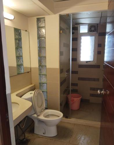 a bathroom with a toilet and a glass shower at GM Hospitality Services pune in Pune