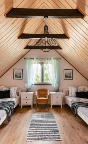 a attic room with two beds and a window at Osada wspomnień in Polańczyk