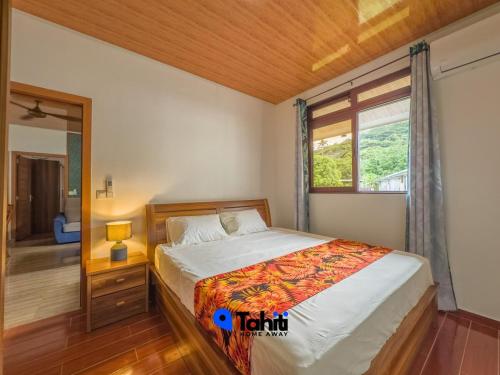 a bedroom with a bed and a window at Moorea Here Lodge house in Atiha