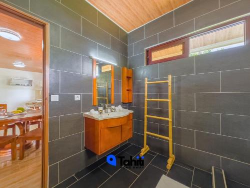 a bathroom with a sink and a mirror at Moorea Here Lodge house in Atiha