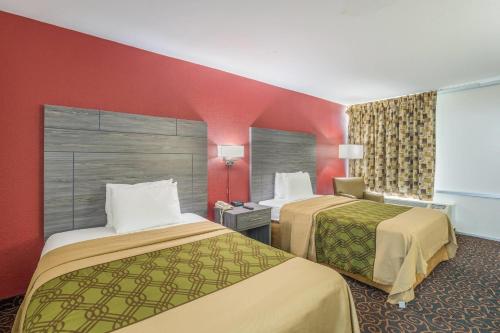 a hotel room with two beds and red walls at Econo Lodge Thomasville in Thomasville
