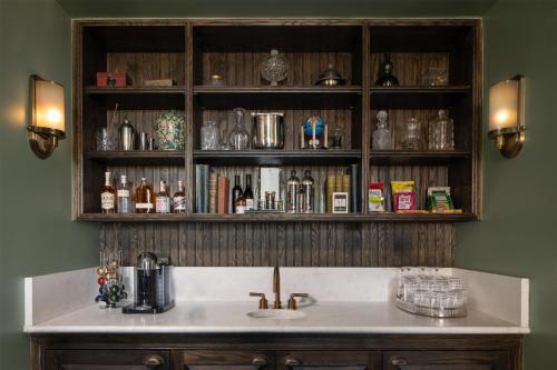 a kitchen with a sink and a shelf with bottles at The Beekman, A Thompson Hotel, by Hyatt in New York