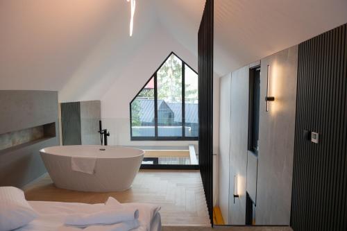 a bathroom with a bath tub and a window at Chalet Port Bicaz in Bicaz