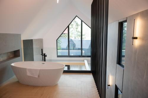 a white bath tub in a bathroom with a window at Chalet Port Bicaz in Bicaz