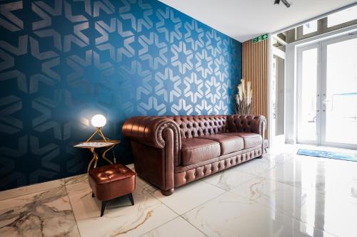 a living room with a brown couch and a blue wall at Stillel Retreat Suites in St. Paul's Bay