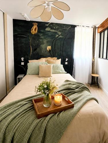 a bed with a tray with candles and flowers on it at Place aux fleurs - Le cocon in Dole
