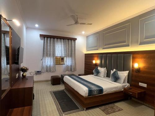 a hotel room with a bed and a television at Hotel Black Stone Palace in Ghaziabad