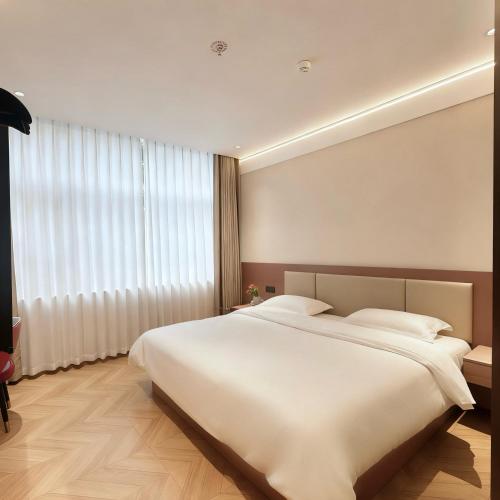 a bedroom with a large bed and a large window at Shenzhen Green Oasis Hotel, Baoan in Bao'an