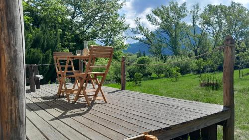 a wooden deck with a chair and a table at Roulotte pour amoureux de la nature in Bugarach