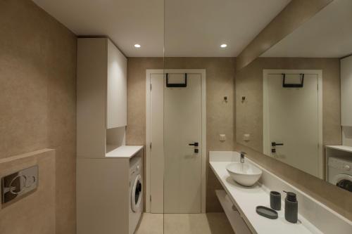 a bathroom with a washing machine and a sink at Tomas Villas in Paleros